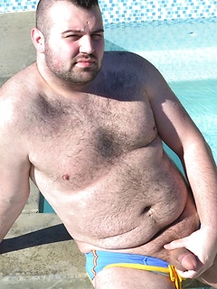 Solo bear Rex Blue sits by the pool in his skimpy swimsuit and jerks off